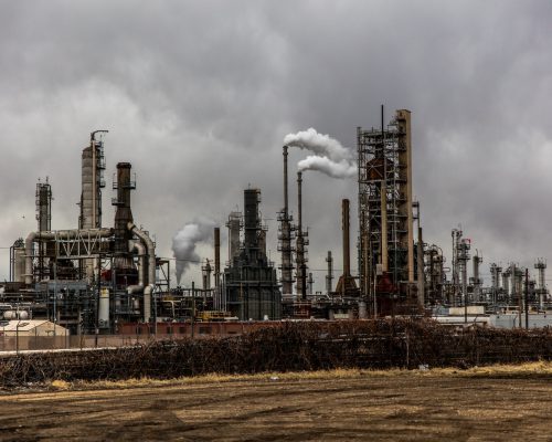 Photo by Patrick Hendry factories with smoke under cloudy sky